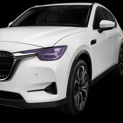 Pre-cut headlight protection film shown tinted lilac on the headlights of a white Mazda CX-60
