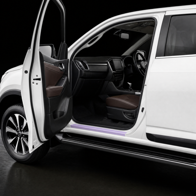 Pre-cut door sill protection film shown tinted lilac on the lower sill of a white Isuzu MU-X